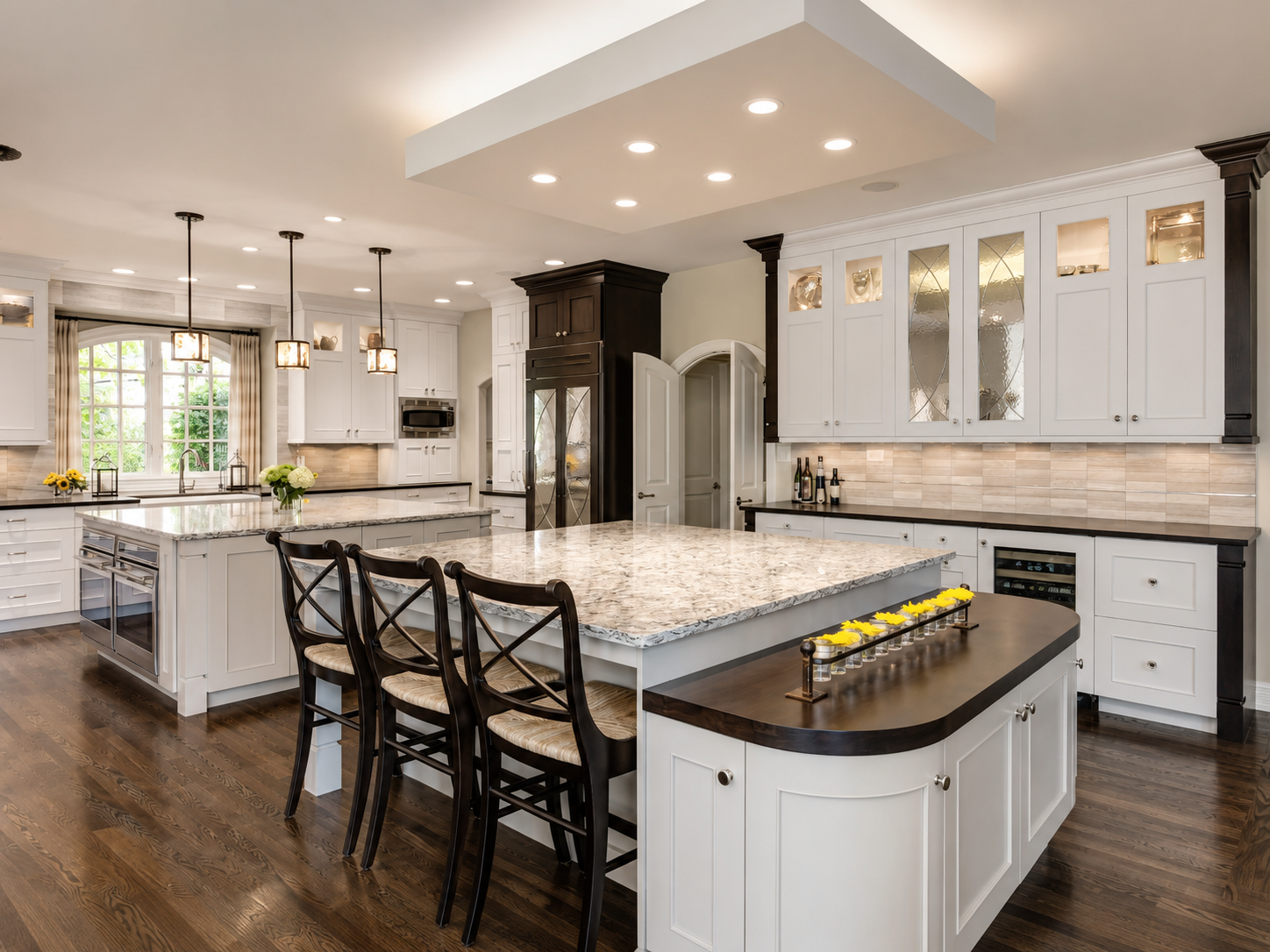 Luxury white kitchen with stainless steel appliances, marble countertops, and elegant pendant lighting