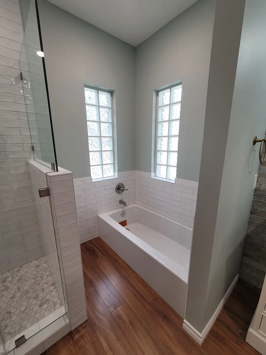 Subway-tiled tub surround with glass block windows and hexagon shower floor
